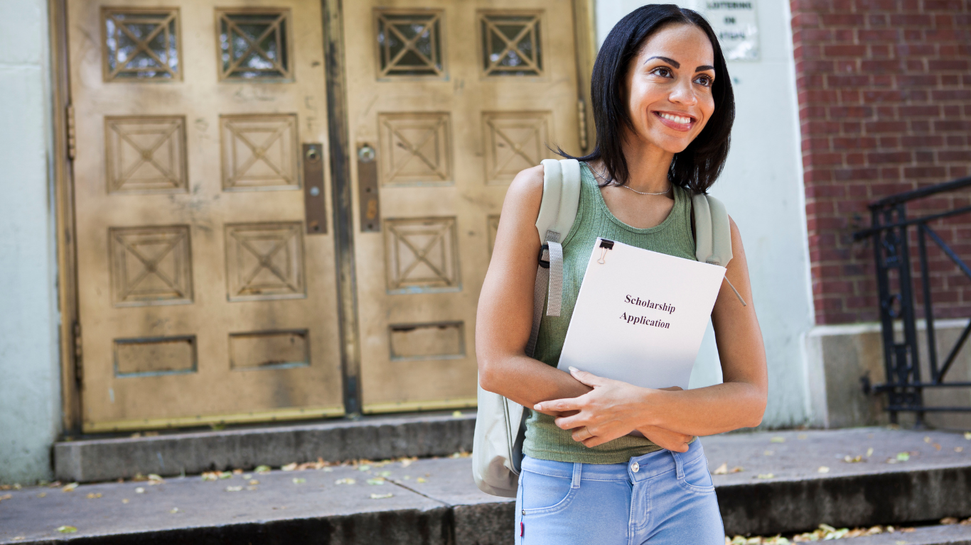 A person is standing in front of a building holding a folder