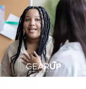 Person with braids talking to another person with long hair.